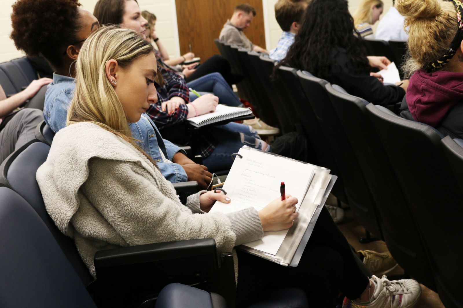 A UMD student takes notes during a lecture 